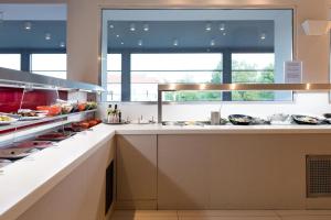 a kitchen with a large window above a counter at Princess Golden Beach Hotel in Chrysi Ammoudia