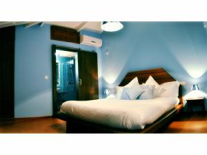 a blue bedroom with a bed with white sheets and pillows at La Posada de Quijada in Granada