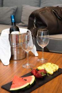 a table with two wine glasses and a plate of fruit at Princess Golden Beach Hotel in Chrysi Ammoudia