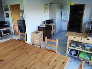 eine Küche mit einem Holztisch und Stühlen in der Unterkunft Entre Sève Et Ciel in Tillet