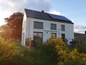 Casa blanca con paneles solares en el techo en Entre Sève Et Ciel, en Tillet