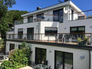 una casa con balcone e sedie di Strandhaus Manatee mit Sauna und Kamin a Ostseebad Sellin