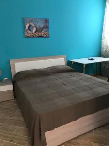 sypialnia z dużym łóżkiem i niebieską ścianą w obiekcie B&B Stella del Mare w mieście Lampedusa