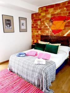 a bedroom with a bed with a brick wall at El Artista in Villajoyosa