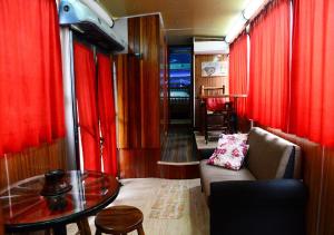 uma sala de estar com cortinas vermelhas, um sofá e uma mesa em Hotel Pousada Mata Nativa em Passo Fundo