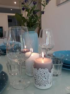 a table with wine glasses and a candle on it at Ferienwohnung Villa Josephine in Badenweiler