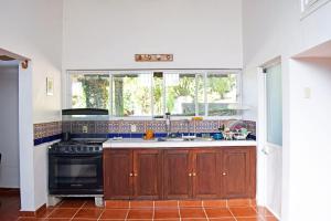 a kitchen with a stove and a sink and a window at Casa de huéspedes vista hermosa in San Agustín Etla