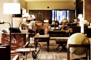 una sala de estar con sofás, sillas y mesas. en Square Nine Hotel Belgrade-The Leading Hotels of The World, en Belgrado