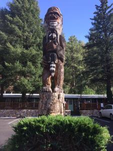 Una statua di un orso in piedi in un parcheggio di Sitzmark Chalet Inn a Ruidoso