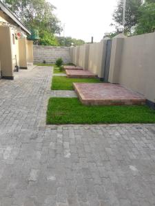 a brick patio with a fence and some grass at Riverside guesthouse B & B in Katima Mulilo