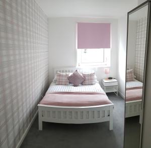 a white bedroom with a bed and a mirror at Bespoke Tours Scotland Accommodation @ Morrison Street in Edinburgh