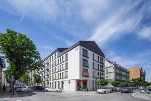 Un edificio blanco con techo negro en una calle. en UNIC Apartments Dominikańska, en Poznan