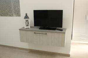 a flat screen tv sitting on top of a cabinet at 197 Pozzo San Nicola in Stintino