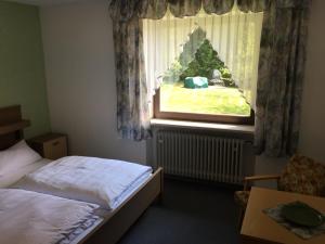 una camera con letto e finestra di Pension Berghof a Schönsee
