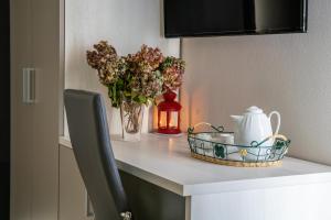 a table with a vase of flowers and a candle at RED ONE in Maranello