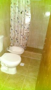 a bathroom with a toilet and a shower curtain at Santo Domingo in Esquina