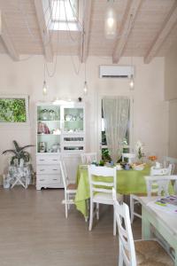 une salle à manger avec une table verte et des chaises blanches dans l'établissement Boccadibacco, à San Pietro in Cariano