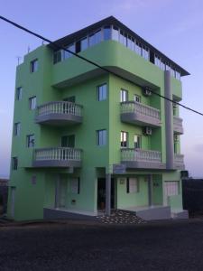 ein grünes Gebäude mit Balkon auf der Seite in der Unterkunft Pensao Motel Sodade in São Filipe