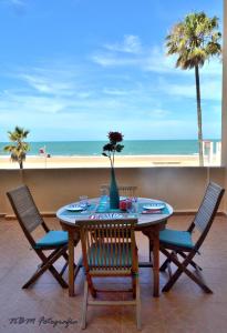 - une table et des chaises avec vue sur la plage dans l'établissement AMAZING FRONTAL BEACH APARTMENT #Traveller's Awards2023, à Cadix