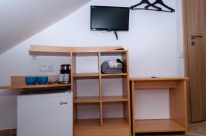 een kamer met een tv en een boekenplank bij Mansarda mica cu baie proprie in Cluj-Napoca