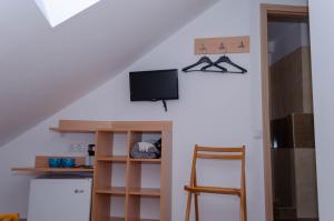 een kamer met een tv en een tafel en een kruk bij Mansarda mica cu baie proprie in Cluj-Napoca