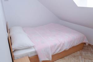 een klein bed met een witte deken erop bij Mansarda mica cu baie proprie in Cluj-Napoca