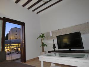 ein Wohnzimmer mit einem Flachbild-TV auf einem Tisch in der Unterkunft Villa Elisa Plaza Mayor in Chinchón