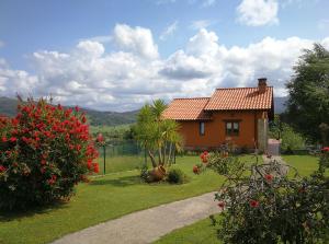 a small house in a yard with red flowers at El MIRADOR DE TONO , Casa entera in Vioño