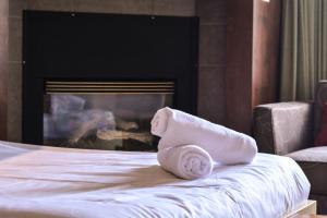 a towel sitting on top of a bed with a fireplace at Estrimont Suites & Spa in Magog-Orford
