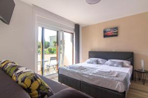 a bedroom with a bed and a balcony at Apartments Edi & Tea in Malinska