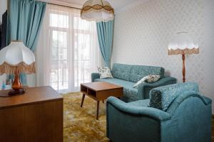 sala de estar con 2 sillas, sofá y mesa en Dacha Resort Hotel en Gelendzhik