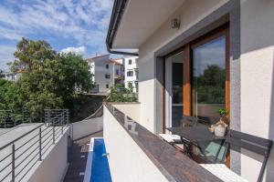 a balcony with a table and a pool at Apartments Edi & Tea in Malinska