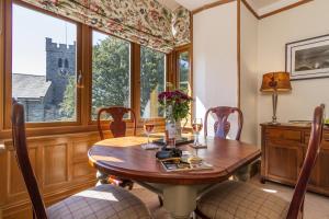 a dining room with a table and chairs and a window at Church View Apartment in Coniston