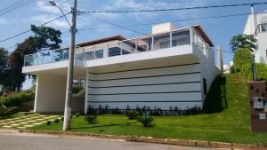 カピトーリオにあるCASA UTOPIA ESCARPAS do LAGOの窓が多い白い家