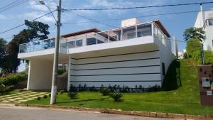 a white house with a lot of windows at CASA UTOPIA ESCARPAS do LAGO in Capitólio