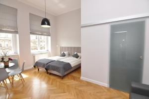 1 dormitorio con 1 cama, mesa y sillas en Wroclaw City Apartments, en Wroclaw