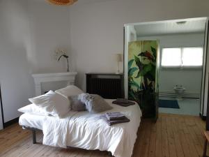 a white bed in a room with a mirror at La Villa Fuberia - Seafront Bassin d'Arcachon in Pyla-sur-Mer