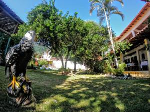 eine Statue eines Adlers auf dem Rasen eines Hauses in der Unterkunft Alfa Mar Pousada in Abraão