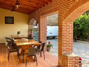 an outdoor patio with a wooden table and chairs at Stone Nest Andros in Andros