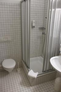 ein Bad mit einer Dusche, einem WC und einem Waschbecken in der Unterkunft Schwarzwald Parkhotel in Königsfeld im Schwarzwald