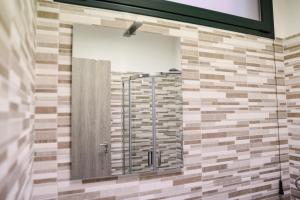 a bathroom with a shower with a mirror at Bed and Breakfast Porto Flavia in Iglesias