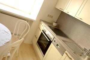 a kitchen with an oven and a sink and a table at BARBARA RESIDENZ - APARTMENT CALLA in Eisenerz
