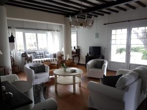 a living room with white chairs and a table at La Villa Fuberia - Seafront Bassin d'Arcachon in Pyla-sur-Mer