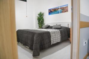 a bedroom with a bed with a black and white blanket at Bed and Breakfast Porto Flavia in Iglesias