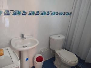 Hostal Palohe Taganga في تاجانجا: حمام به مرحاض أبيض ومغسلة