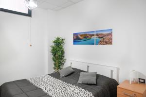 a bedroom with a bed and a picture on the wall at Bed and Breakfast Porto Flavia in Iglesias
