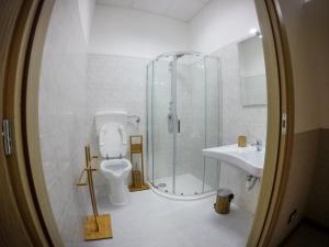 a bathroom with a shower and a toilet and a sink at Bed and Breakfast Porto Flavia in Iglesias