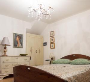 a bedroom with a bed and a chandelier at B&B Alba Sul Lago in Pergine Valsugana