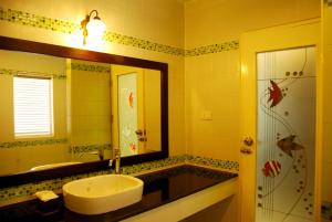 a bathroom with a sink and a shower and a mirror at Ananda Villa - SHA Plus in Koh Tao