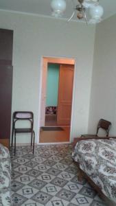 コムソモリスク・ナ・アムーレにあるGostinitsa Mayakのベッド2台、椅子、ドアが備わる客室です。